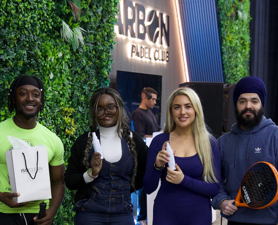 Four people at a padel club holding ISOSKIN spray bottles